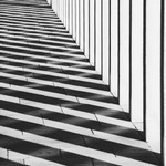 Abstract black and white photo of architectural shadows creating geometric patterns.