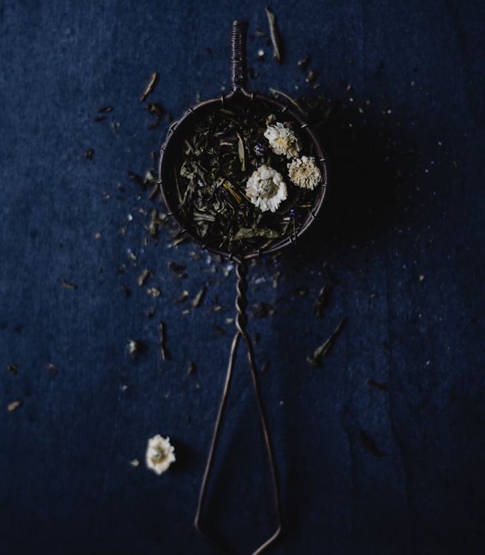 Minimalist still life with tea and natural herbs on a dark table